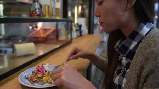 デンマーク料理店で食べる女性は 市場の屋台カウンターで伝統的な臭みのあるオープンサンドイッチを食べます デンマークからの典型的な食事をしようとして幸せなアジアの観光客 コペンハーゲン市内旅行ライフスタイル — ストック動画