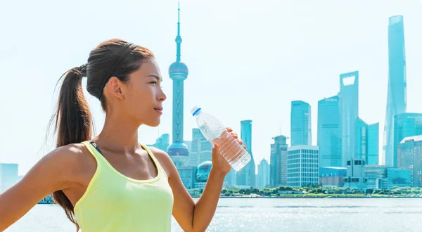 健康的なアクティブなライフスタイルランナーの女の子は 夏の暑さの中で喉の渇き上海スカイラインフィットネスアジアの女性で水ボトルを飲む 中国のパノラマバナー 健康とスポーツ — ストック写真