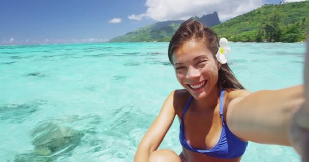 フランス領ポリネシアのエキゾチックな熱帯の休暇先で豪華な水上バンガローで自撮りをしている幸せな笑顔のアジアの女の子 夏休みを楽しむビキニ女性 — ストック動画