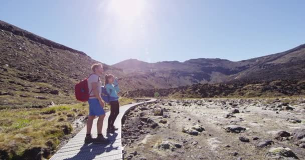 ハイキング中にマウント ナウルホーを撮影した女性と男性のバックパッカー トンガリロ国立公園でのアクティブな若いカップルのハイキング 旅行と夏休みのコンセプト — ストック動画