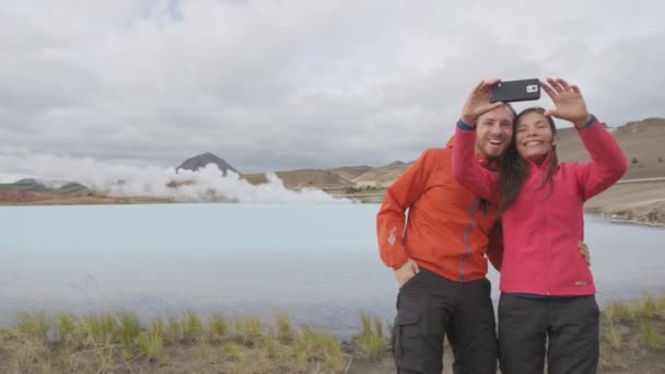 冰岛的一对旅游夫妇带着电话自拍旅行 Myvatn湖地区Namafjall的地热发电厂和温泉边的居民 在冰岛自然景观中度假的情侣 — 图库视频影像