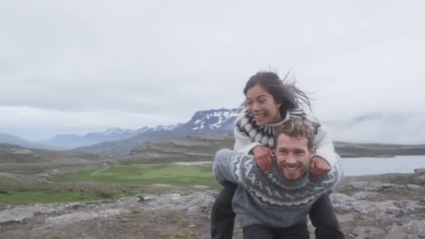 부부가 아이슬란드의 스웨터를 피기백을 하면서 즐겁고 장난기있게 웃으면서 아이슬란드에서 재미있게 — 비디오