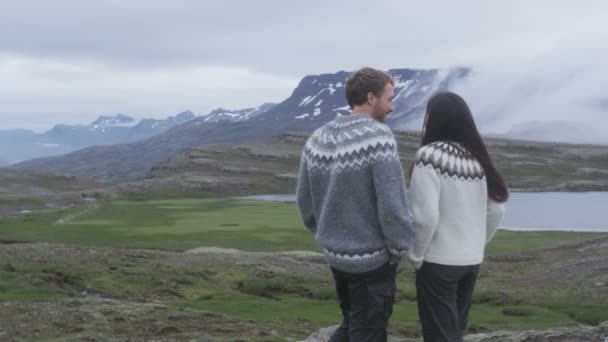 男人和女人穿着冰岛毛衣在山上观看冰岛的自然景观 妇女和男子模式享受健康的户外生活方式 Fps — 图库视频影像