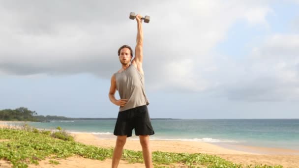 健身哑铃男在海滩上与哑铃一起做力量训练健身练习 适合男性健身模特在海滩上做举重运动 — 图库视频影像