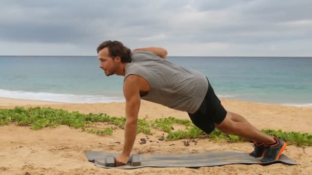 ダンベル プラン フィットネスマンは ビーチで外を行使しながらダンベルを使用して行の運動を交換 — ストック動画