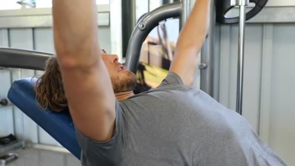 Fitnessmann Fitnessstudio Trainiert Brustmuskeln Beim Flachen Bankdrücken Mit Der Langhantel — Stockvideo