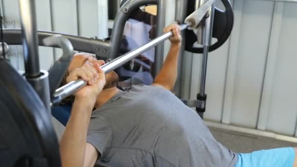健身锻炼员练习胸肌 用杠铃按压扁平板凳 史密斯机床台式机 Fps慢动作 男运动员运动 — 图库视频影像