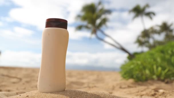 해수욕장의 휴양지인 해수욕장에서 모래에 선크림 병입니다 선크림 플라스틱 Protection Skincare — 비디오