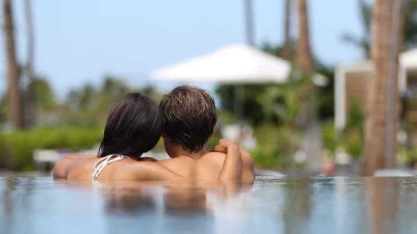 蜜月夫妇在豪华度假胜地温泉度假胜地的一个无限大游泳池里放松地在一起 豪华旅馆业度假 难以辨认的人放松地享受暑假 — 图库视频影像