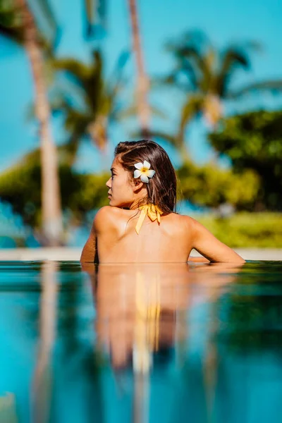 豪华度假胜地的女人在无限大的游泳池里度假 身穿比基尼 头戴水仙花的亚洲年轻人在海滨度假胜地的游泳池里度假或外出旅游 — 图库照片