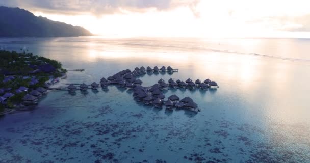 ビーチでサンゴ礁ラグーンの海で水上バンガローと熱帯休暇の楽園の島の空中ビデオ ムーアの空中ビデオ フランス領ポリネシア タヒチ 南太平洋 — ストック動画