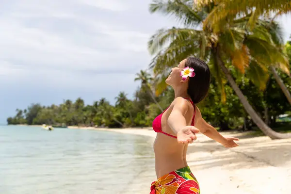 ハッピーフリー夏休みビーチビキニボディー女性は スカートと花のパラダイスビーチで日光浴を無料で楽しんでいます 画像はメイクなしで取り外し モデル化されています ラウド イメージ ストック写真