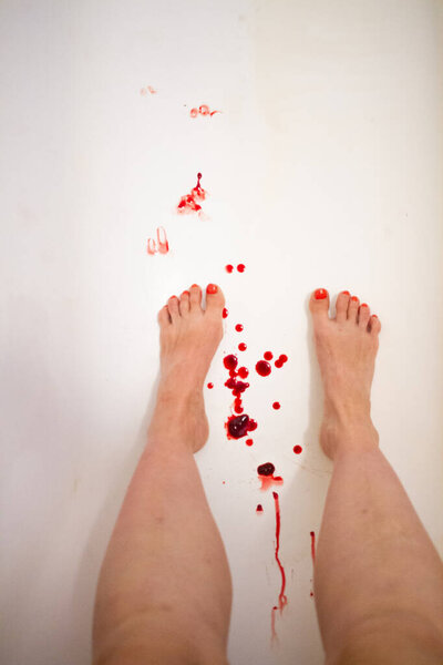 Woman legs and feet with red nails on a bath tube with menstrual period blood drops on white background, menstrual cup background vertical