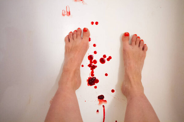Woman legs and feet with red nails on a bath tube with menstrual period blood drops on white background, menstrual cup background vertical