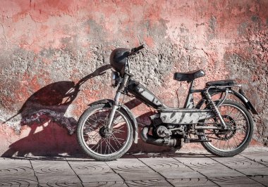 vintage motorcycle on aged reddish wall in Marrackech, Morocco