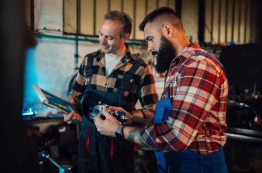Fabrikadaki genç bir makinistin çalışmalarını değerlendiren kıdemli bir mühendis. O, işten memnun. Elinde bir dosya tutuyordu. Genç makinist onun yaptığı yönleri gösteriyor. Tulumlar, gömlekler..
