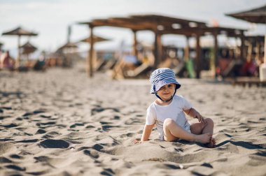 Plajda oynayan ve yaz tatilinde gülümseyen bir çocuğun portresi. Mutlu çocuk dışarıda eğlenmekten zevk alıyor. Sahilde yaşam tarzı. Kameraya bakıyorum..
