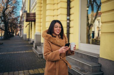 Genç İspanyol kadın şehir dışında akıllı telefon kullanıyor.