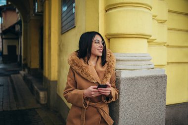 Genç İspanyol kadın şehirde akıllı telefon kullanıyor.