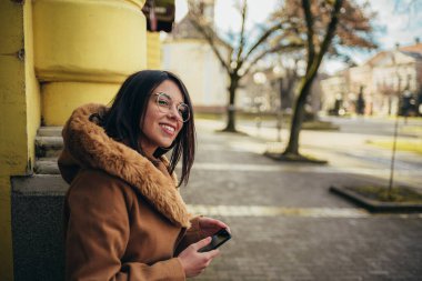 Çekici bir İspanyol kadının şehirdeki en iyi kafeyi bulmak için akıllı telefon kullanması.
