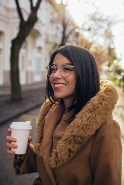 Şehirde paltolu genç İspanyol kadın kahve içerken...