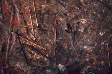 Ressam stüdyosunun kirli zemininde fırça darbeleri. Sanatçı için aracın üst görünümü, sanat için renkli boyalı farklı boyutlarda fırçalar.