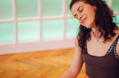 Gülümseyen beyaz bir kızın sabah esnemesinin tadını çıkarırken başını bir yana eğip boynunu uzattığı yakın çekim. Sabah antrenmanının tadını çıkarıyorum. Boşluğu kopyala.