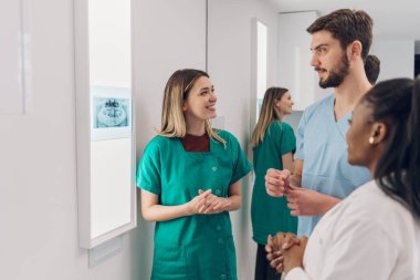 Bir grup doktor hastanede çalışırken çene röntgenine bakıyor. Çok ırklı ağız cerrahları. Sağlık, sağlık ve radyoloji kavramı.