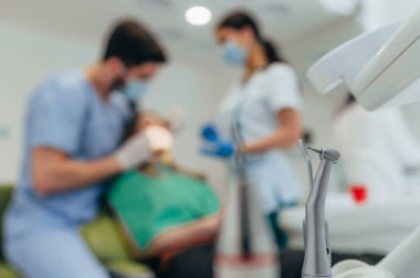 Bir dişçi kliniğindeki elektrikli el aletine ya da hava türbinine odaklan. Diş hekimi hastasına yardım ederken geçmişi bulanık..