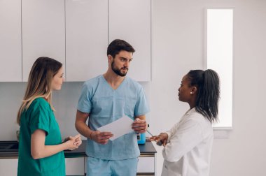 Cerrahlardan oluşan çok ırklı tıbbi ekip hastanede acil bir toplantı yapıyor. Bir grup doktor vardiyalarında birlikte çalışırken bir hasta durumundan bahsediyorlar..