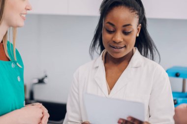 Hastanedeki hastalar üzerinde çalışan çeşitli doktor ekipleri. Tıp personeli modern hastane içinde tartışıyorlar. Sağlık ve tıp konsepti. Afro-Amerikan bir doktora odaklan.