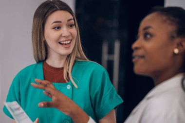 Hastanedeki bir toplantı odasında konuşurken hastanın sağlık durumunu tartışan bir grup genç doktor. Cerrahi ve tıp konsepti. Kafkasyalı bir kadın doktora odaklan.