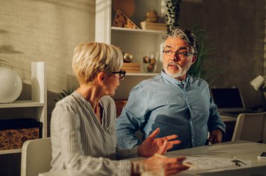 Yeni evlerinin planlarını hazırlarken yaşlı yaşlı bir çift masada oturuyor. İpotek bankası onayı, aile bütçesi planlaması, bir eve yatırım. Bir adama odaklan..