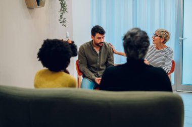 Grup terapisine katılan çok ırklı yetişkinler grubu. Üst düzey bir kadın, destek grubu toplantısında hikayesini anlatırken genç bir adamı teselli ediyor. İncinebilirlik, toplum ve akıl sağlığı.