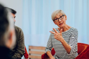 Yetişkin bir kadının portresi grup terapisinde zihinsel sorunları tartışıyor ve üç numarayı elleriyle gösteriyor. İyileşen bağımlılar psikolog ve toplum desteği alıyorlar. Boşluğu kopyala.