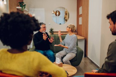Grup terapisindeki iki olgun hastanın portresi. İki son sınıf öğrencisi terapi seansı sırasında el kol hareketleri yapıyor. Akıl sağlığı konsepti. Sorunlardan bahsediyorum..