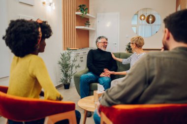 Yetişkin bir kadın psikoloğun portresi grup terapisinde hastalarla tanışıyor ve gri saçlı bir adamı teselli ediyor. Kıdemli danışman terapi seansında insanlara tavsiye veriyor. Ruh sağlığı konsepti.