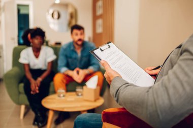 Ofiste terapi seansı sırasında erkek psikiyatrist hastalarıyla konuşuyor. Akıl sağlığı danışmanı. Psikoterapi hizmetleri, akıl sağlığı profesyonel konsepti. Not alan bir doktora odaklan..