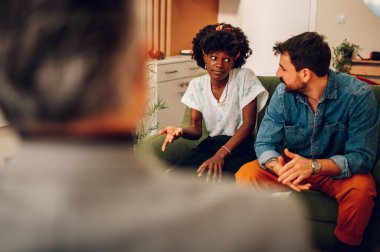 Çeşitli çiftler ofiste evlilik terapistiyle psikoterapi seansı yapıyorlar. Çok ırklı bir çift terapide sorunlar hakkında konuşuyor. Evlilik terapisi. Afrika kökenli Amerikalı bir kadına odaklan..