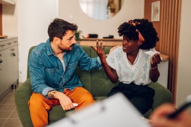 Ofiste bir psikologla seansta olan çok ırklı genç bir çift. İlişki sorunları, boşanmaktan kaçınmak. Profesyonel terapist eşleri yardım isterken kavga ediyorlar. Ağlayan kadın.