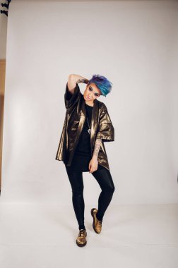 Stüdyoda renkli makyajlı beyaz bir arka planda güzel bir genç kız. Moda, güzellik, makyaj, kozmetik. Makyajlı kadın modelin güzel portresi. Poz verirken ayakta.