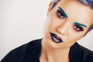 Stüdyoda renkli makyajlı beyaz bir arka planda güzel bir genç kız. Moda, güzellik, makyaj, kozmetik. Canlı makyajlı kadın modelin güzel portresi..