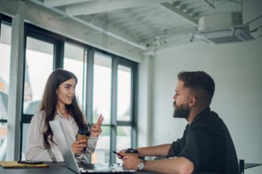 Zeki odaklı genç iş kadını ofisteyken motive olmuş bir erkek arkadaşla bir dizüstü bilgisayarla projeyi tartışıyor. Yeni proje ya da görev tartışılıyor. Bilgi paylaşımı.