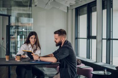 Erkek ve bayan meslektaşlar satış raporlarını ve iş çizelgelerini tartışıyor ve toplantılarında işbirliği yapıyorlar. Ofis arkadaşları birlikte proje planlıyor.