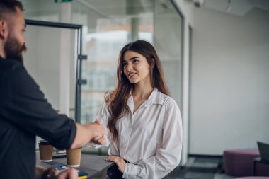 Açık bir uzay ofisinde anlaşma ya da ortaklık yapan iki iş adamı el sıkışıyor. Ofisteki beyin fırtınası ekibindeki yeni meslektaşımıza hoş geldin diyoruz..