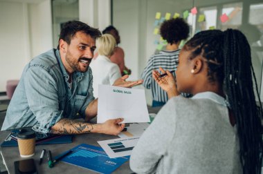 İki farklı iş adamı bir ofiste sohbet ediyorlar. Heyecanlı Afro-Amerikan kadın fikirleri paylaşıyor ya da beyaz erkek iş arkadaşıyla yeni bir iş planı yapıyor. İş molası kavramı. Çok ırklı takım.