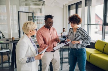Şirketin aylık toplantısına, şirketin yıllık satış raporunu katılımcılara tartışan çok ırklı iş adamlarına eşlik eden çeşitli iş arkadaşları tarafından kullanılan belgeleri tartışıyorlardı..