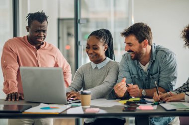 Modern bir şirketin toplantı odasında dizüstü bilgisayarın etrafında çalışan çeşitli yaratıcı iş adamları. Beyin fırtınası konsepti. Ofis hayatı. Çok ırklı meslektaşlar.
