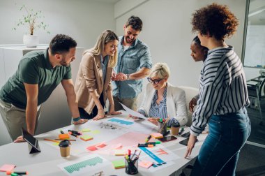 Şirket brifinginde birlikte çalışan mutlu çok ırklı iş ekibi ofiste toplandı. Yönetim kurulundaki çeşitli meslektaşlar mali istatistikleri tartışıyorlar..