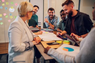 Şirket brifinginde birlikte çalışan mutlu çok ırklı iş ekibi konferans odasında toplandı. Yönetim kurulunda birlikte iş tartışırken gülümseyen meslektaşlar..